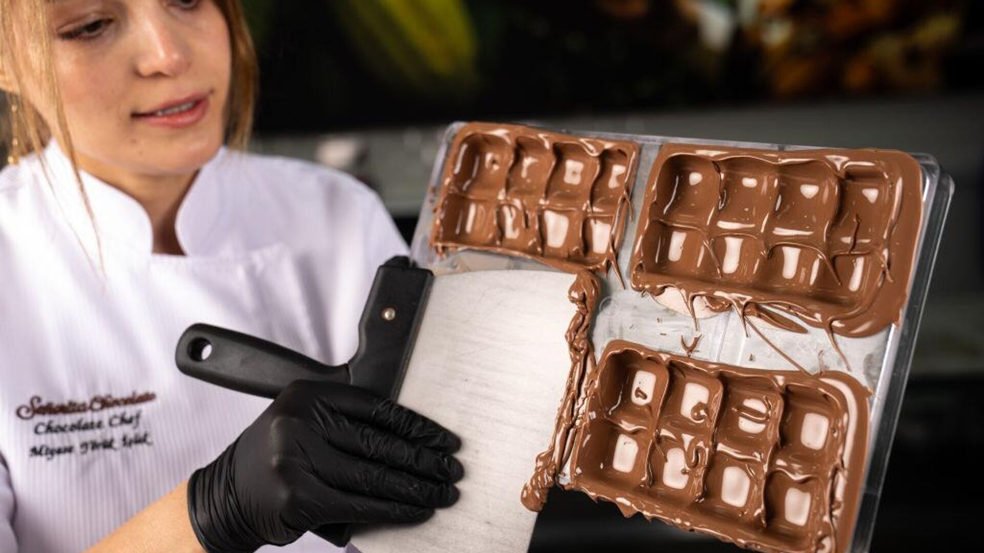 Una mujer retira chocolate sobrante mientras rellena un molde para una tableta de chocolate durante Dubai Chocolate en Ankara, Turquía, 29 de octubre de 2024 Una mujer retira chocolate sobrante mientras rellena un molde para una tableta de chocolate durante Dubai Chocolate en Ankara, Turquía, 29 de octubre de 2024 - Sputnik Mundo, 1920, 26.12.2024