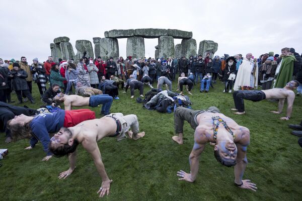 El solsticio de invierno en Stonehenge se celebra con una reunión al amanecer o al atardecer del día más corto del año. Las personas se reúnen para presenciar la alineación del sol con las piedras y participar en rituales espirituales.En la foto: un grupo de participantes en las celebraciones del solsticio de invierno en Stonehenge, en el Reino Unido. - Sputnik Mundo