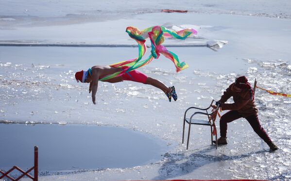 Practicante de natación de invierno saltando en el río Amarillo, en la ciudad china de Shenyang. - Sputnik Mundo
