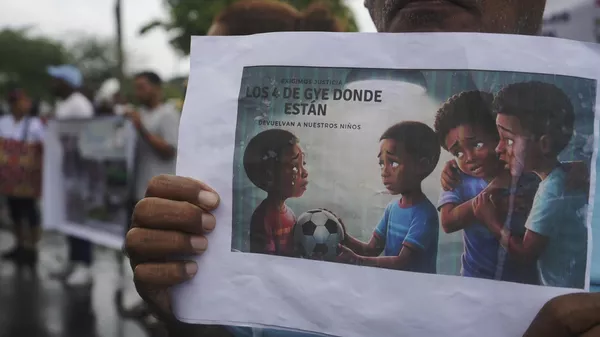 Un manifestante sostiene un cartel con la frase: Los 4 de Guayaquil dónde están, devuelvan a nuestros niños - Sputnik Mundo
