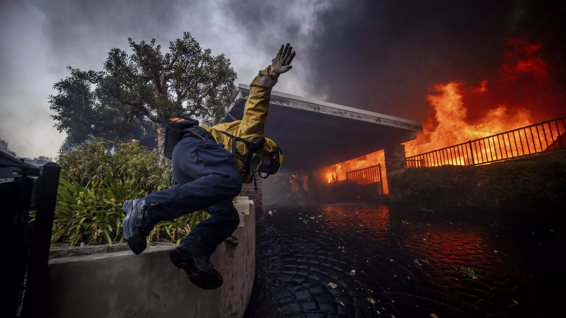 Un bombero salta una valla mientras lucha contra un incendio en Los Ángeles, EEUU - Sputnik Mundo, 1920, 23.01.2025