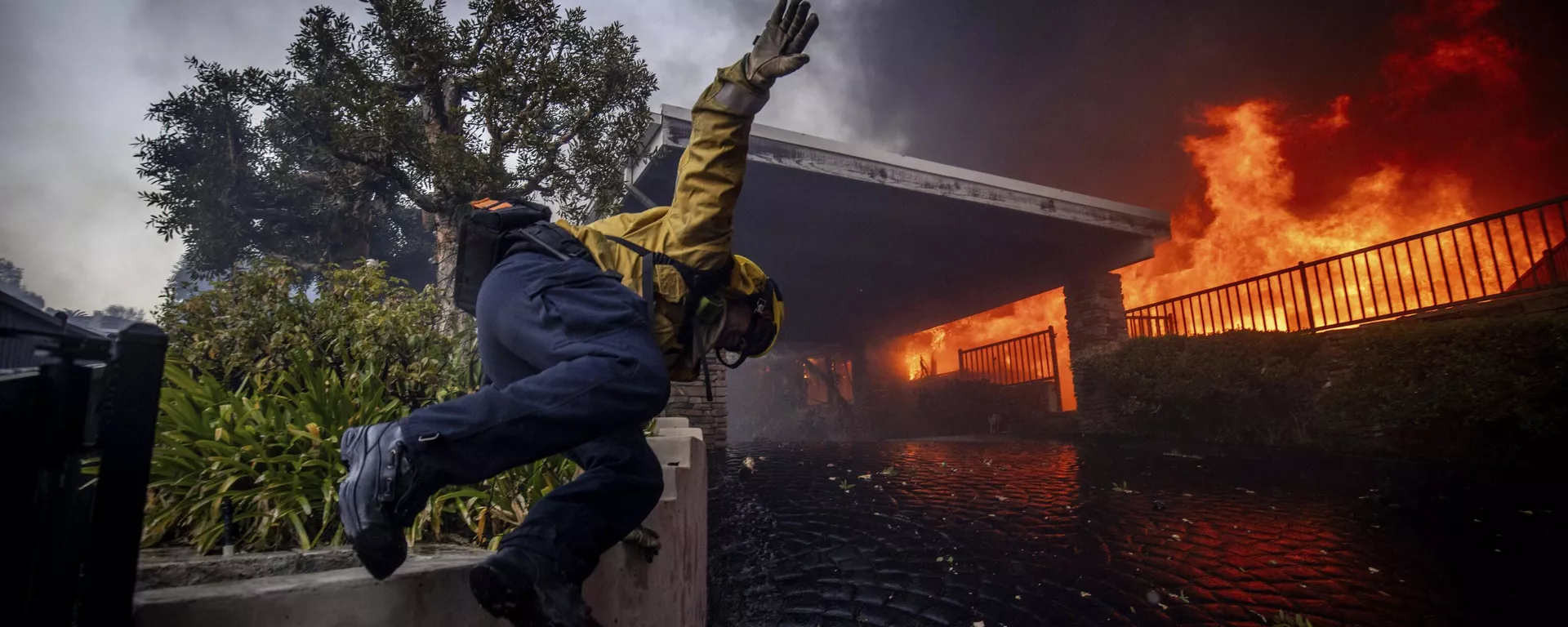 Un bombero salta una valla mientras lucha contra un incendio en Los Ángeles, EEUU - Sputnik Mundo, 1920, 23.01.2025