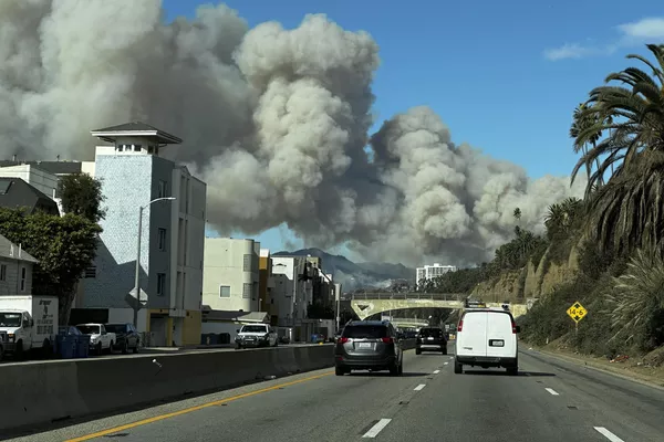 El espeso humo del incendio de Pacific Palisades se eleva sobre la autopista Pacific Coast en Santa Mónica. - Sputnik Mundo