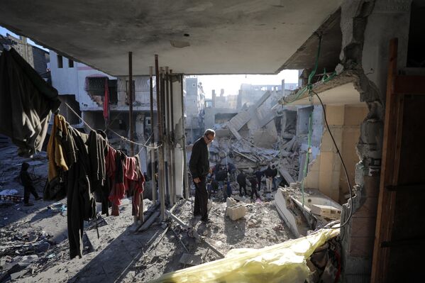Palestinos observan los destrozos tras un ataque israelí en el campo de refugiados de Bureij, en el centro de la Franja de Gaza. Palestinos observan los destrozos tras un ataque israelí en el campo de refugiados de Bureij, en el centro de la Franja de Gaza. - Sputnik Mundo