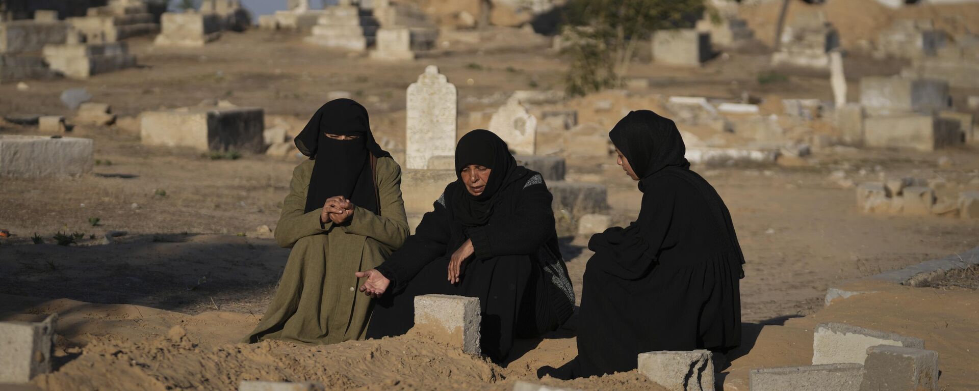 Mujeres palestinas rezan en un cementerio donde están enterrados sus familiares muertos por un ataque aéreo israelí, en Jan Yunis, Gaza, 9 de enero de 2025 - Sputnik Mundo, 1920, 21.04.2025
