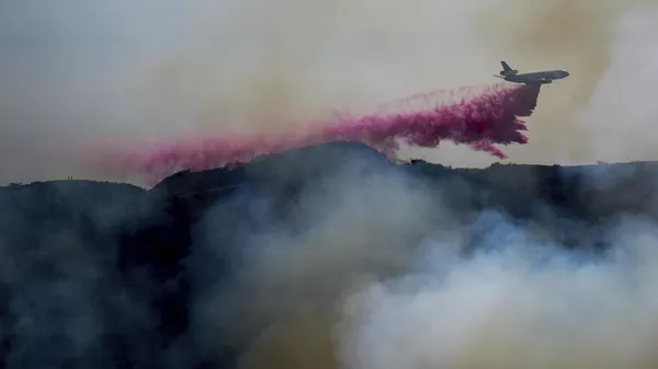 Un camión cisterna arroja retardante de fuego en el incendio Palisades, en las afueras del vecindario Pacific Palisades de Los Ángeles, el 10 de enero de 2025 - Sputnik Mundo
