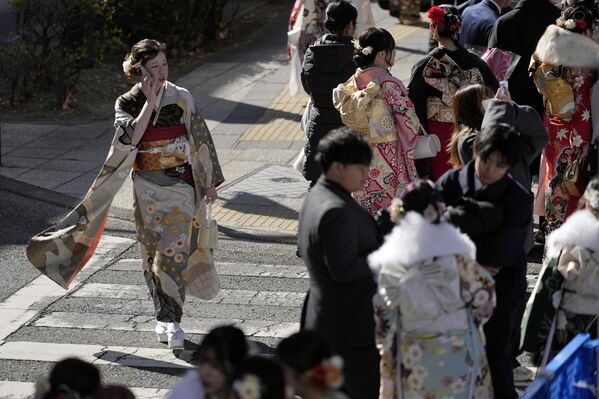 Una mujer vestida con kimono camina mientras celebra el Día de la mayoría de edad, una tradición centenaria y fiesta nacional que celebra el paso de niño a adulto, en Yokohama, cerca de Tokio. Una mujer vestida con kimono camina mientras celebra el Día de la mayoría de edad, una tradición centenaria y fiesta nacional que celebra el paso de niño a adulto, en Yokohama, cerca de Tokio. - Sputnik Mundo