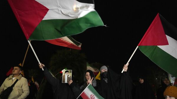 Manifestantes ondean banderas palestinas e iraníes mientras uno de ellos sostiene un cartel del líder supremo iraní, el ayatolá Ali Jamenei, en una celebración por el anuncio de un acuerdo de alto el fuego entre Hamás e Israel, en la plaza Felestin (Palestina) de Teherán, Irán, 16 de enero de 2025 - Sputnik Mundo