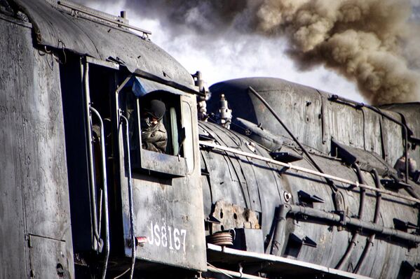 El joven chino Raymond Zhang, de tan solo 14 años, recibió el premio en la categoría de joven fotógrafo de viajes del año 2024 por su reportaje de un antiguo tren de vapor y sus maquinistas, fotografiado en plena acción.Se trata de una mina de carbón de Sandaoling en la ciudad de Hami (provincia de Xinjiang, China). - Sputnik Mundo