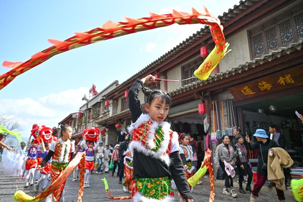 Las empresas públicas, escuelas, universidades y muchas otras instituciones permanecen cerradas durante las fiestas.En la foto: unos niños interpretan la danza del dragón en un desfile folclórico tradicional en la prefectura autónoma de Honghe Hani y Yi, provincia china de Yunnan. - Sputnik Mundo