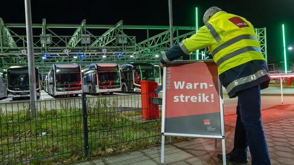 Un conductor de autobús coloca un cartel en el que se lee ¡Huelga de advertencia! en el aparcamiento del transporte público en el municipio de Schenefeld, estado de Schleswig-Holstein, Alemania, el 31 de enero de 2025 - Sputnik Mundo