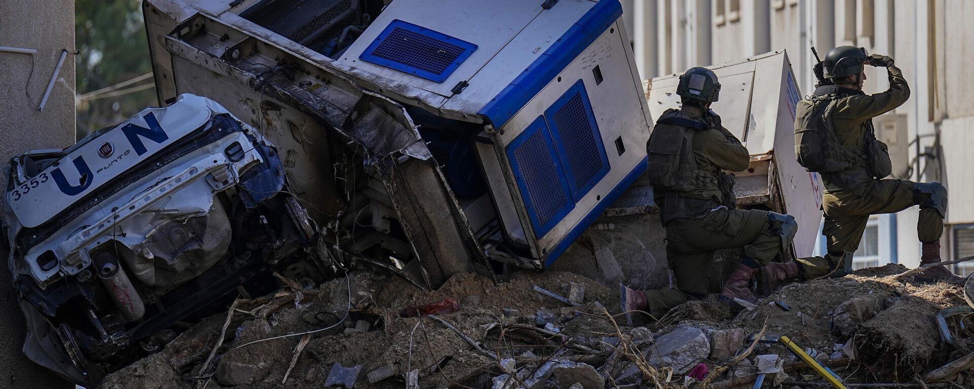 Soldados israelíes toman posición junto a vehículos de la ONU arrugados y precariamente encaramados sobre escombros en el complejo de la UNRWA, el jueves 8 de febrero de 2024 - Sputnik Mundo, 1920, 01.02.2025