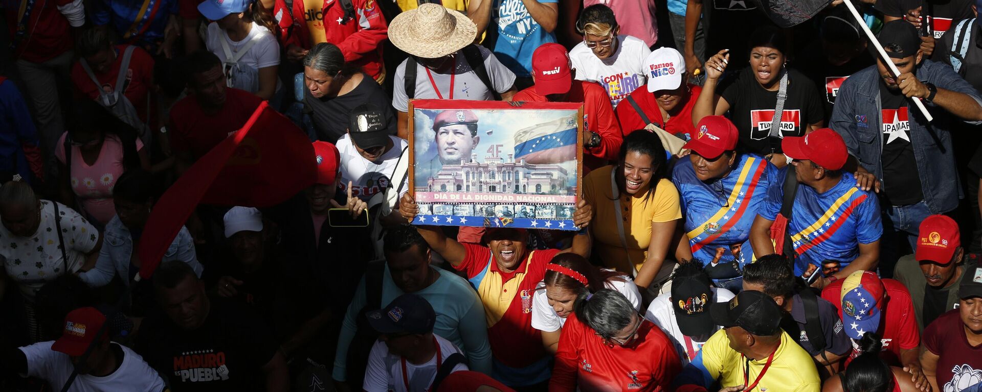 Un partidario del Gobierno de Venezuela sostiene un póster del fallecido presidente venezolano Hugo Chávez durante un acto para conmemorar el aniversario del fallido intento de golpe de Estado de Chávez en 1992 en Caracas, Venezuela, el martes 4 de febrero de 2025. - Sputnik Mundo, 1920, 12.02.2025