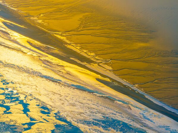 Cuando las mareas de agua marina arrastran los sedimentos, la escarcha pinta increíbles cuadros de naturaleza en las orillas. - Sputnik Mundo