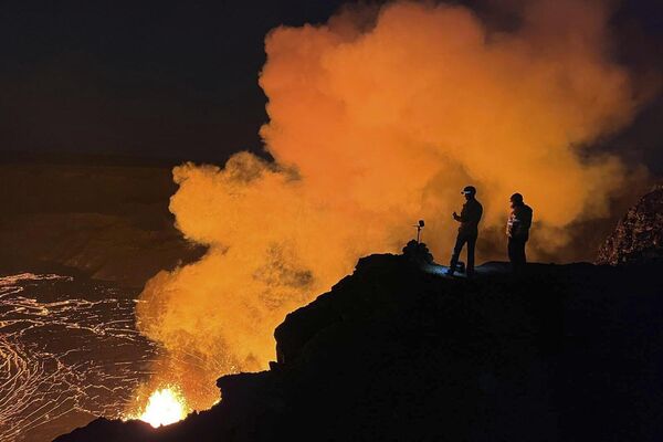 Geólogos observan una fuente de lava desde el cráter Halemaumau, en la cima del volcán Kilauea, en el Parque Nacional de los Volcanes de Hawái. Actualmente, es uno de los volcanes más activos del planeta. - Sputnik Mundo