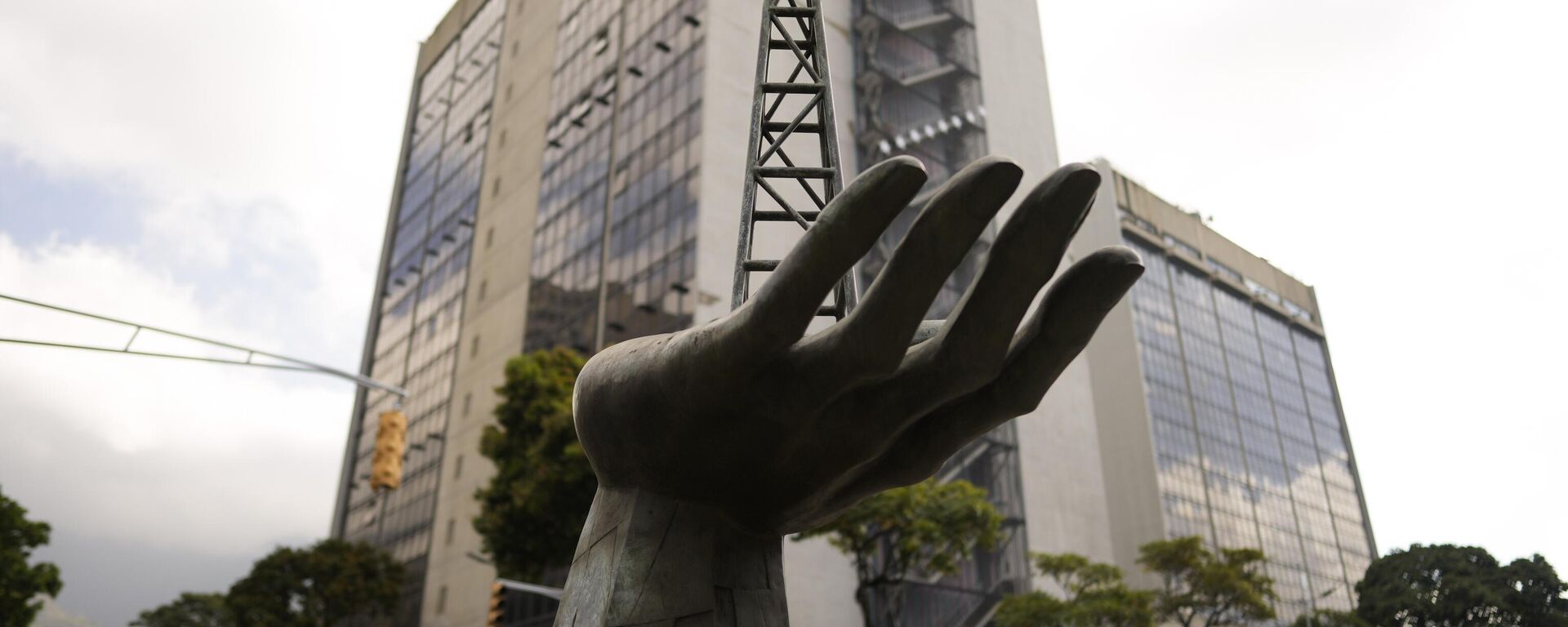 Una escultura de una mano sosteniendo una plataforma de perforación petrolera frente a la compañía petrolera estatal Petróleos de Venezuela S.A. o PDVSA, en Caracas, Venezuela, el 21 de marzo de 2023. - Sputnik Mundo, 1920, 17.12.2025