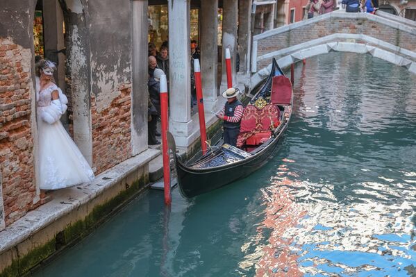 Una turista disfrazada posa para un retrato junto a una góndola el 15 de febrero de 2025 en Venecia, Italia. - Sputnik Mundo