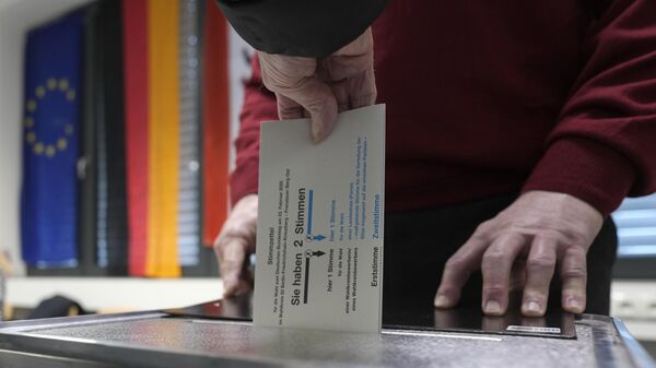 Un residente deposita su voto en un centro de votación de Berlín, Alemania, el 23 de febrero de 2025, durante las elecciones nacionales alemanas - Sputnik Mundo