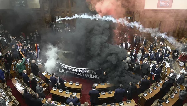 En esta captura de video facilitada por la emisora Radio Televisión Serbia, los diputados lanzan bombas de humo y bengalas en el edificio del Parlamento, en Belgrado.La disputa se produjo después de que los legisladores de la oposición se levantaran de sus escaños exigiendo la dimisión del Gobierno, culpando a las autoridades de la muerte de más de una docena de personas al derrumbarse una marquesina en una estación de ferrocarril de la ciudad de Novi Sad, el 1 de noviembre. - Sputnik Mundo