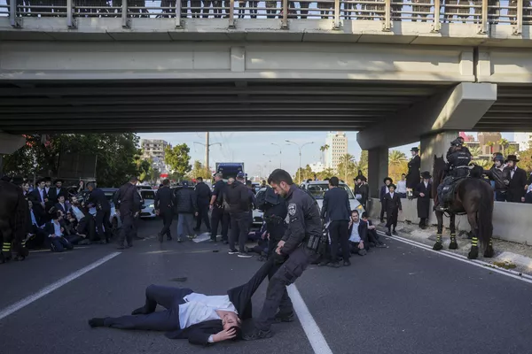 Agentes de Policía israelíes dispersan a hombres judíos ultraortodoxos que bloquean una carretera durante una protesta contra su reclutamiento en el Ejército, en la ciudad de Bnei Brak, Israel. - Sputnik Mundo