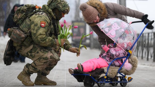 Un cadete felicita a una niña en el Día Internacional de la Mujer en Novosibirsk, Rusia - Sputnik Mundo