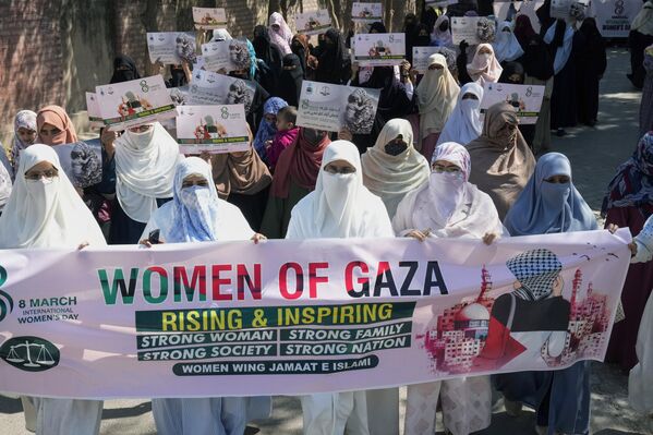 Mujeres sostienen pancartas en apoyo a las mujeres de Gaza durante una manifestación con motivo del Día Internacional de la Mujer, en Lahore, Pakistán. - Sputnik Mundo