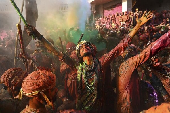 Residentes de localidades indias de Barsana y Nandgaon embadurnados de colores, cantan y bailan mientras participan en festival hindú Lathmar Holi. - Sputnik Mundo
