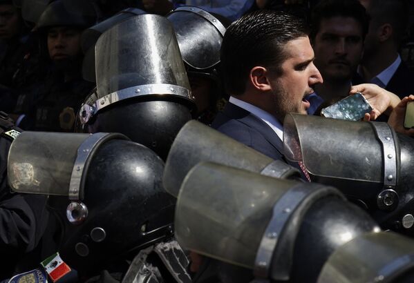 Pedro Enrique Haces Lago, diputado del partido Morena en el Congreso de la Ciudad de México, visiblemente molesto y protegido por policías después de que se aprobara el dictamen que prohíbe las corridas de toros violentas, tras la iniciativa presentada por la alcaldesa Clara Brugada, en la ciudad de México, el 18 de marzo de 2025. - Sputnik Mundo
