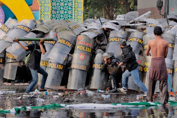 Manifestantes luchan con agentes de la Policía antidisturbios durante una concentración contra la aprobación de una controvertida revisión de una ley militar que permitirá a los militares ocupar más cargos en el Gobierno sin tener que dimitir de las Fuerzas Armadas, en Surabaya, Java Oriental, Indonesia. Manifestantes luchan con agentes de la Policía antidisturbios durante una concentración contra la aprobación de una controvertida revisión de una ley militar que permitirá a los militares ocupar más cargos en el Gobierno sin tener que dimitir de las Fuerzas Armadas, en Surabaya, Java Oriental, Indonesia. - Sputnik Mundo