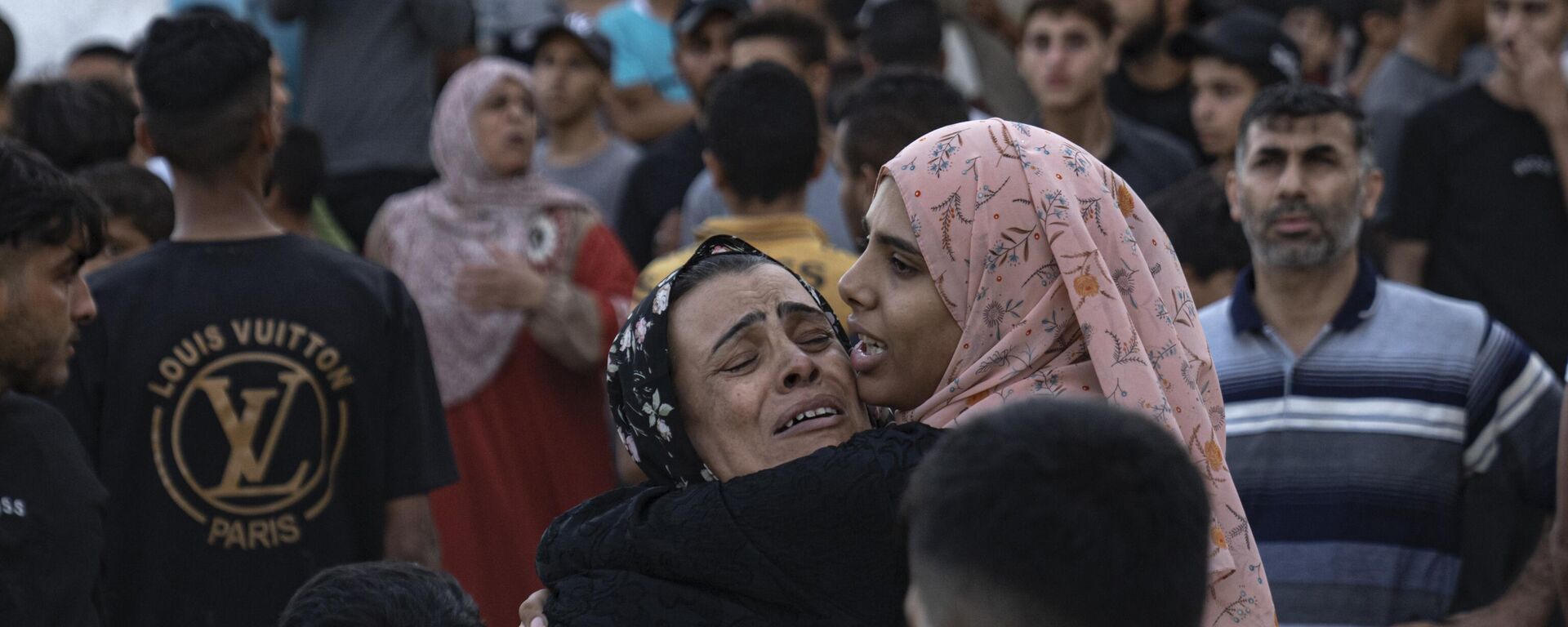 Mujeres llorando se abrazan, Franja de Gaza, el 21 de octubre de 2023.  - Sputnik Mundo, 1920, 26.04.2025