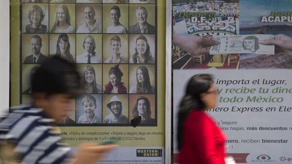 Personas pasan junto a letreros que anuncian servicios de transferencia de dinero al exterior de un negocio en la Ciudad de México (archivo) - Sputnik Mundo