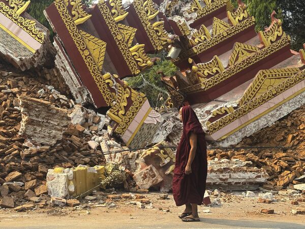 Un monje budista camina cerca de una pagoda derrumbada tras el terremoto en la ciudad birmana de Mandalay. Un monje budista camina cerca de una pagoda derrumbada tras el terremoto en la ciudad birmana de Mandalay. - Sputnik Mundo