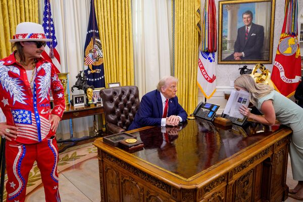 El presidente de EEUU, Donald Trump, acompañado por el cantante Kid Rock, dialoga con la secretaria de Prensa de la Casa Blanca, Karoline Leavitt, antes de firmar una orden ejecutiva en el Despacho Oval de la Casa Blanca en Washington D. C. El presidente de EEUU, Donald Trump, acompañado por el cantante Kid Rock, dialoga con la secretaria de Prensa de la Casa Blanca, Karoline Leavitt, antes de firmar una orden ejecutiva en el Despacho Oval de la Casa Blanca en Washington D. C. - Sputnik Mundo
