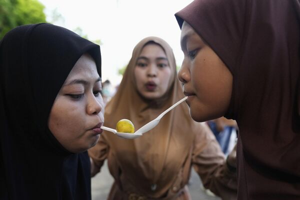 Aíd al Fitr, también conocida como Fiesta de ruptura del ayuno, es una festividad islámica que se celebra para conmemorar el fin del ayuno durante el mes de Ramadán.En la foto: Fieles portando calamondina (Citrofortunella microcarpa) con cucharas en un juego durante la celebración del Aíd al Fitr en Filipinas. Aíd al Fitr, también conocida como Fiesta de ruptura del ayuno, es una festividad islámica que se celebra para conmemorar el fin del ayuno durante el mes de Ramadán.En la foto: Fieles portando calamondina (Citrofortunella microcarpa) con cucharas en un juego durante la celebración del Aíd al Fitr en Filipinas. - Sputnik Mundo