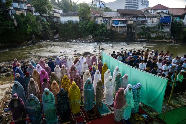 Musulmanes indonesios asisten a un oficio religioso con motivo de la festividad de Aíd al Fitr a orillas de un río en la provincia de Java Occidental. Musulmanes indonesios asisten a un oficio religioso con motivo de la festividad de Aíd al Fitr a orillas de un río en la provincia de Java Occidental. - Sputnik Mundo