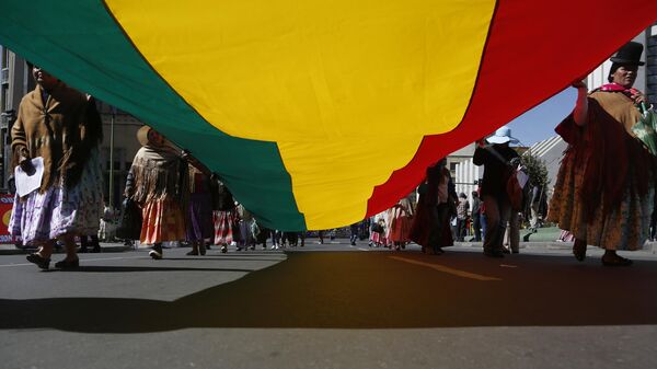 Mujeres indígenas portan una bandera boliviana durante una marcha del Primero de Mayo en La Paz, Bolivia - Sputnik Mundo