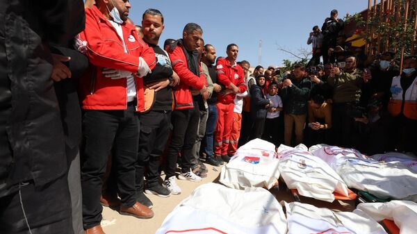 Trabajadores de la Media Luna Roja Palestina despiden a sus compañeros muertos en un ataque israelí en la Franja de Gaza. - Sputnik Mundo