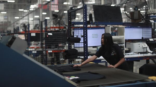 Una empleada trabaja en una fábrica textil que produce camisetas, en Ciudad Juárez, México.  - Sputnik Mundo