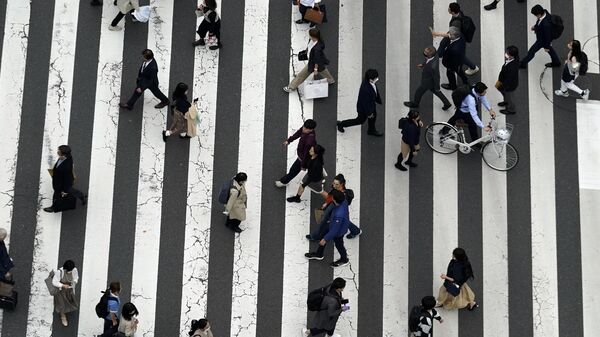 Gente camina por un paso de peatones en la calle comercial Ginza, en Tokio. японское население - Sputnik Mundo