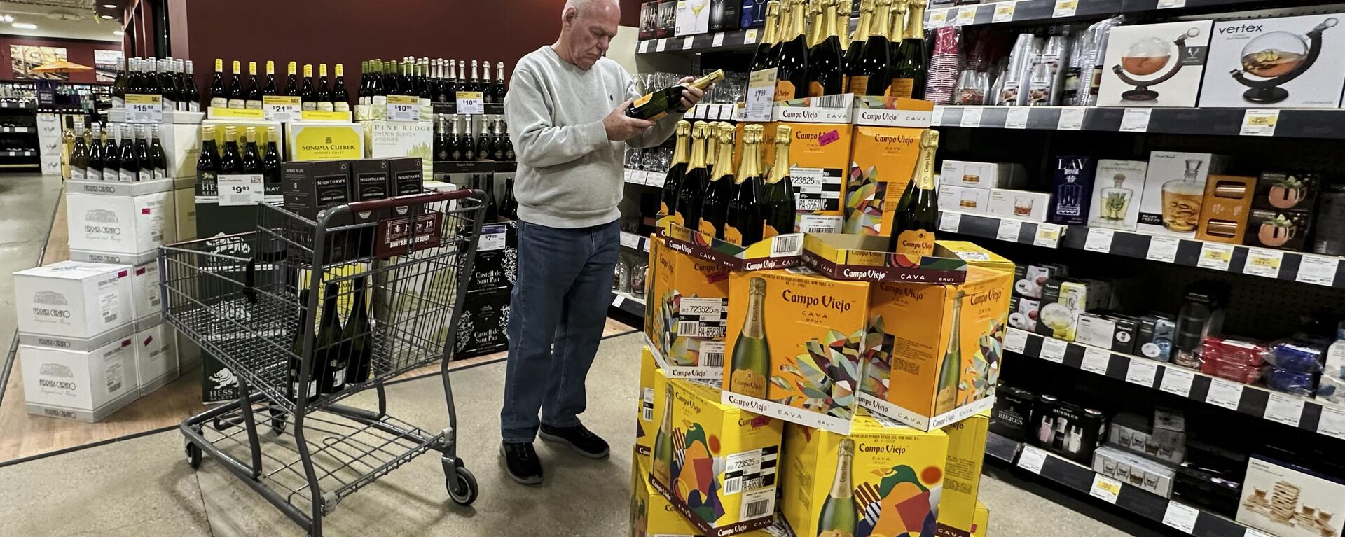Un comprador revisa el costo de una botella de vino espumoso español de venta en una tienda de Niles, Illinois, EEUU - Sputnik Mundo, 1920, 16.04.2025
