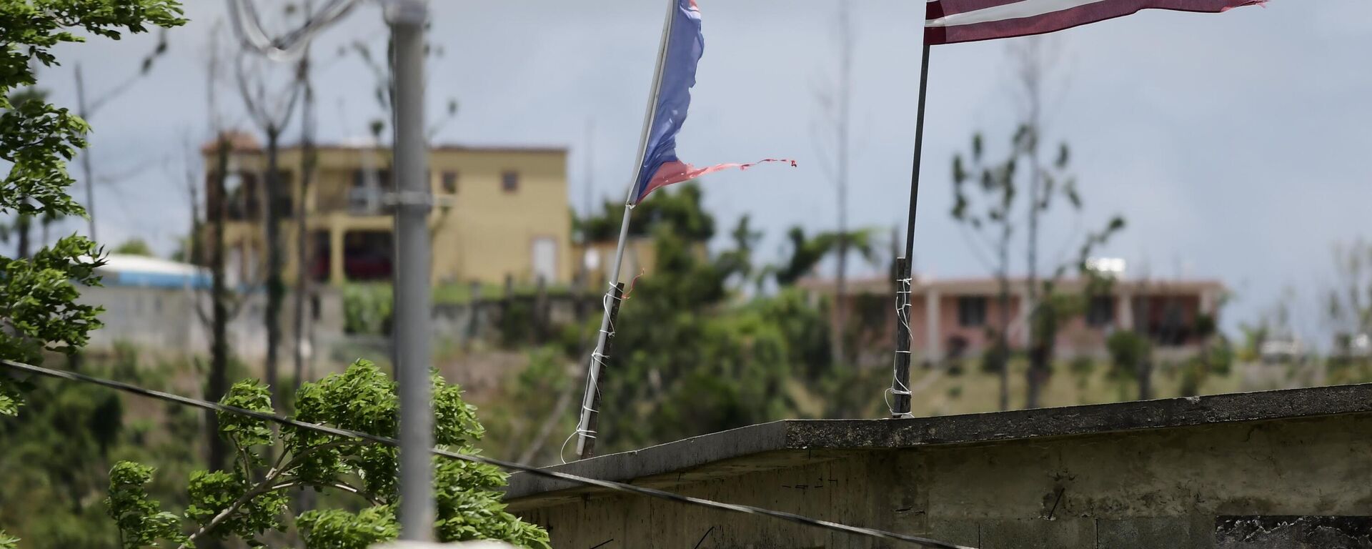 Banderas deterioradas de Estados Unidos y Puerto Rico ondean en un tejado ocho meses después del paso del huracán María en el Barrio Jacana Piedra Blanca de Yabucoa, en Puerto Rico, el 16 de mayo de 2018.  - Sputnik Mundo, 1920, 17.04.2025