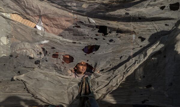 Palestinos en la zona de un campamento para civiles desplazados en la ciudad de Jan Yunis, en la Franja de Gaza, afectado por un ataque aéreo israelí. Palestinos en la zona de un campamento para civiles desplazados en la ciudad de Jan Yunis, en la Franja de Gaza, afectado por un ataque aéreo israelí. - Sputnik Mundo