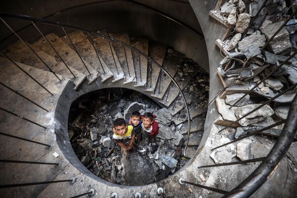 Niños palestinos juegan en el interior del destruido centro cultural Rashad al Shawa, en la Franja de Gaza. Niños palestinos juegan en el interior del destruido centro cultural Rashad al Shawa, en la Franja de Gaza. - Sputnik Mundo