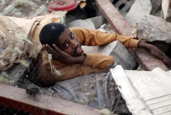 Un migrante africano espera ayuda entre los escombros de una prisión, después de lo que los hutíes declaran que fue un ataque aéreo estadounidense que destruyó una prisión. El bombardeo mató a docenas de personas e hirió a muchos más en la provincia de Saada, Yemen. Un migrante africano espera ayuda entre los escombros de una prisión, después de lo que los hutíes declaran que fue un ataque aéreo estadounidense que destruyó una prisión. El bombardeo mató a docenas de personas e hirió a muchos más en la provincia de Saada, Yemen. - Sputnik Mundo