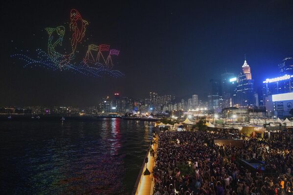 Las personas observan un espectáculo con drones que representa el Festival Tin Hau en la costa del puerto Victoria, durante el feriado del 1 de mayo en Hong Kong. - Sputnik Mundo