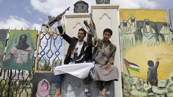 Partidarios de los hutíes corean consignas frente a pancartas de apoyo a los palestinos, durante una manifestación contra Estados Unidos e Israel en Saná, Yemen. - Sputnik Mundo