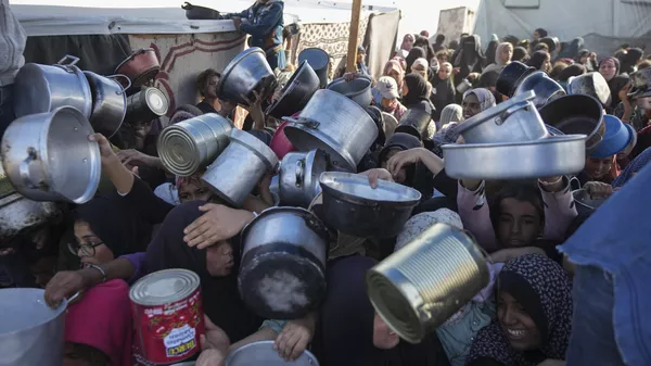 Mujeres palestinas en espera de alimentos en el centro de distribución en la ciudad gazatí de Jan Yunis (imagen referencial) - Sputnik Mundo