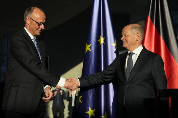 El recién elegido canciller alemán, Friedrich Merz (a la izquierda) estrecha la mano del excanciller Olaf Scholz durante la ceremonia de traspaso de poderes en la Cancillería de Berlín. - Sputnik Mundo