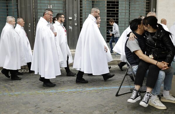 Una pareja se abraza mientras miembros de los Templarios Católicos de Italia caminan en una procesión silenciosa, de camino a rezar dentro del Panteón, después de visitar la Basílica de San Pedro en Roma, Italia. - Sputnik Mundo