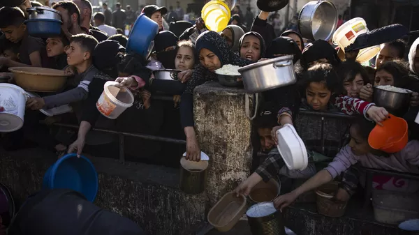 Palestinos hacen fila para recibir una comida gratuita en la ciudad de Rafah, al sur de la Franja de Gaza (archivo) - Sputnik Mundo